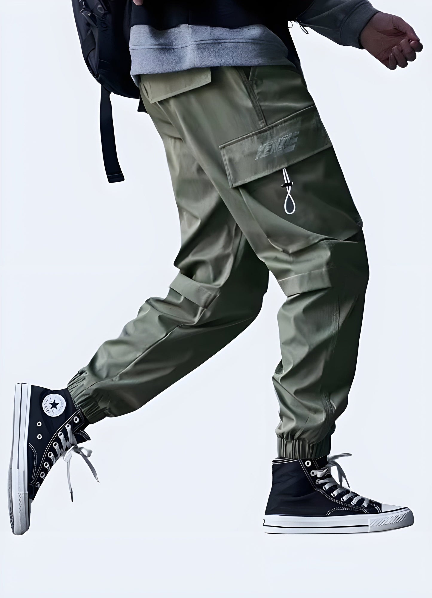 Side view of a man wearing fashion-forward baggy techwear pants, emphasizing the garment's voluminous shape and cutting-edge design, ideal for streetwear aficionados in the UK.