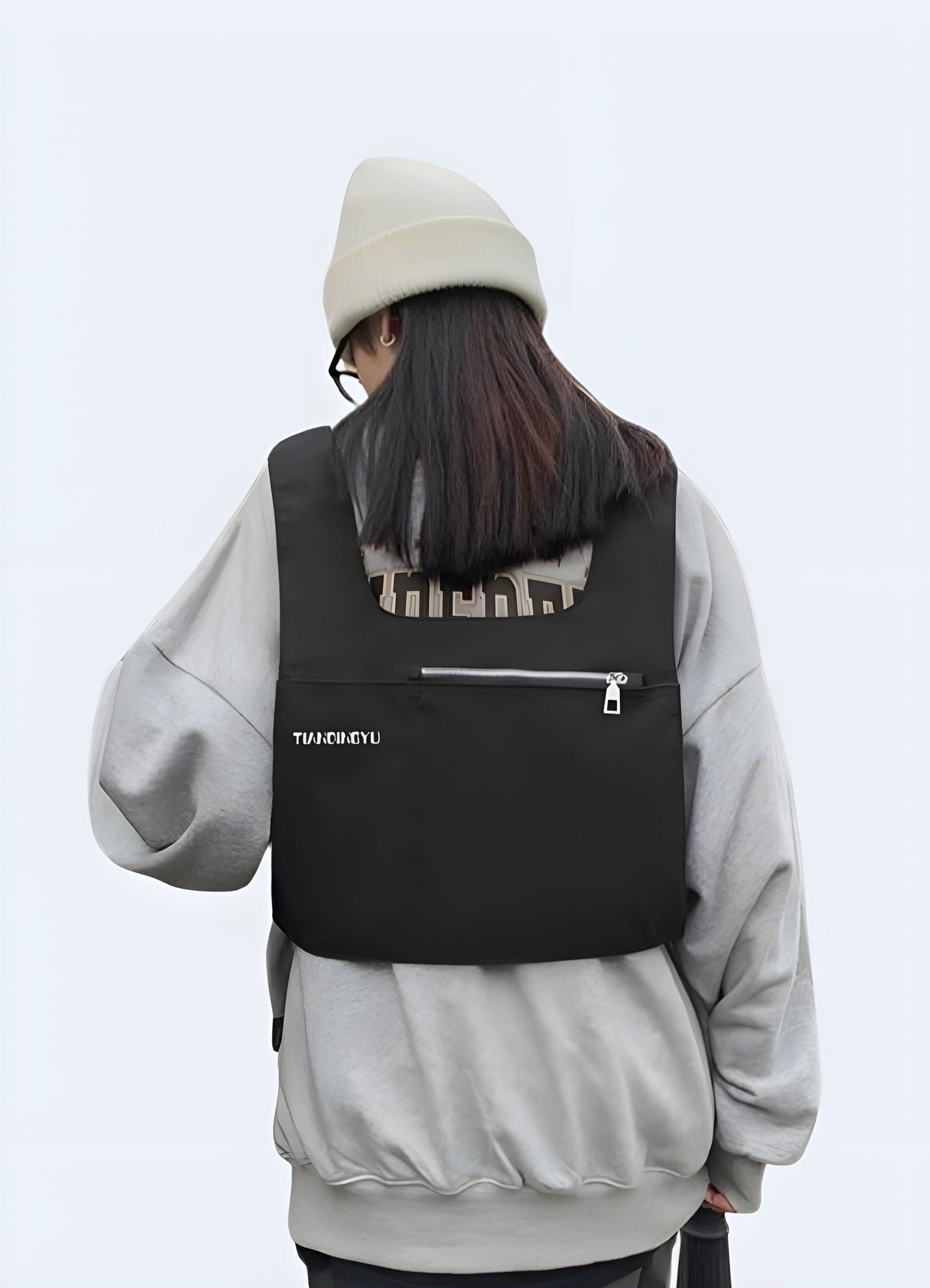 Woman showcasing the back view of a black tactical chest bag, demonstrating its versatility in the UK.