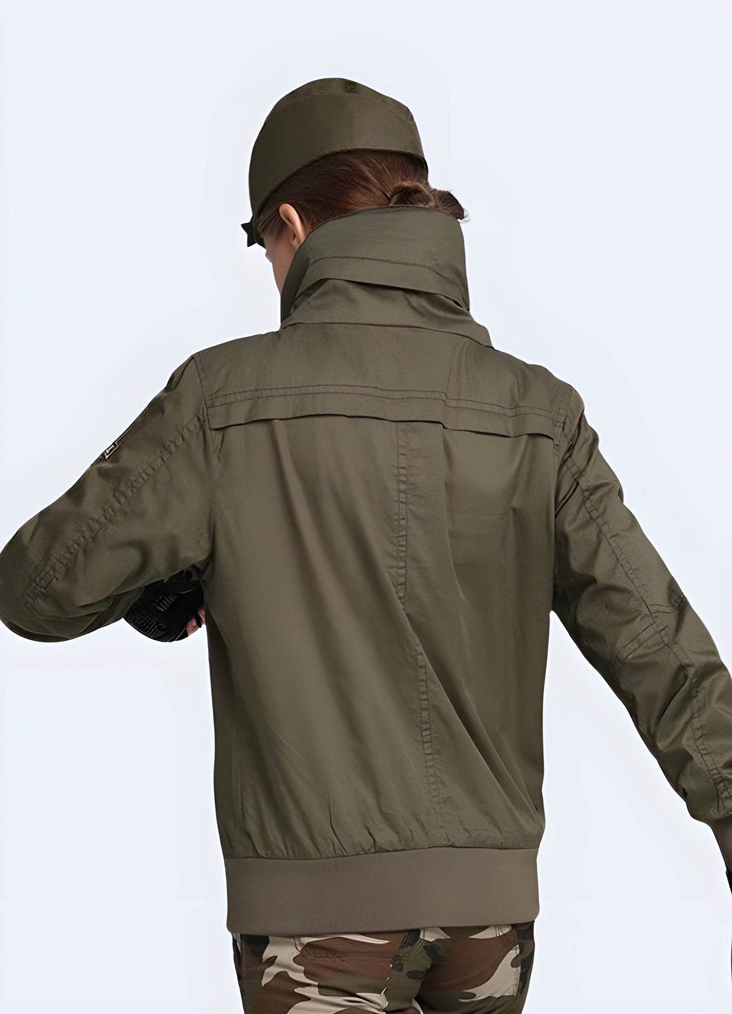 A back side view of a woman sporting a rugged and fashionable UK-made women's tactical jacket, highlighting the garment's superior construction and attention to detail.