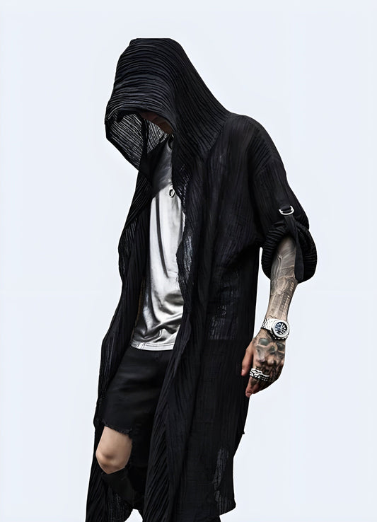 Front view of a man wearing a black cloak with a hood, showcasing its mysterious and edgy style for a bold fashion statement in the UK.