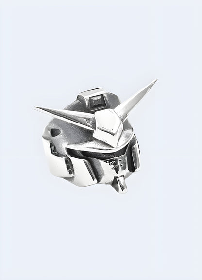 The ring, designed in the UK, exhibits detailed Gundam-inspired elements and is positioned to highlight its profile and craftsmanship.