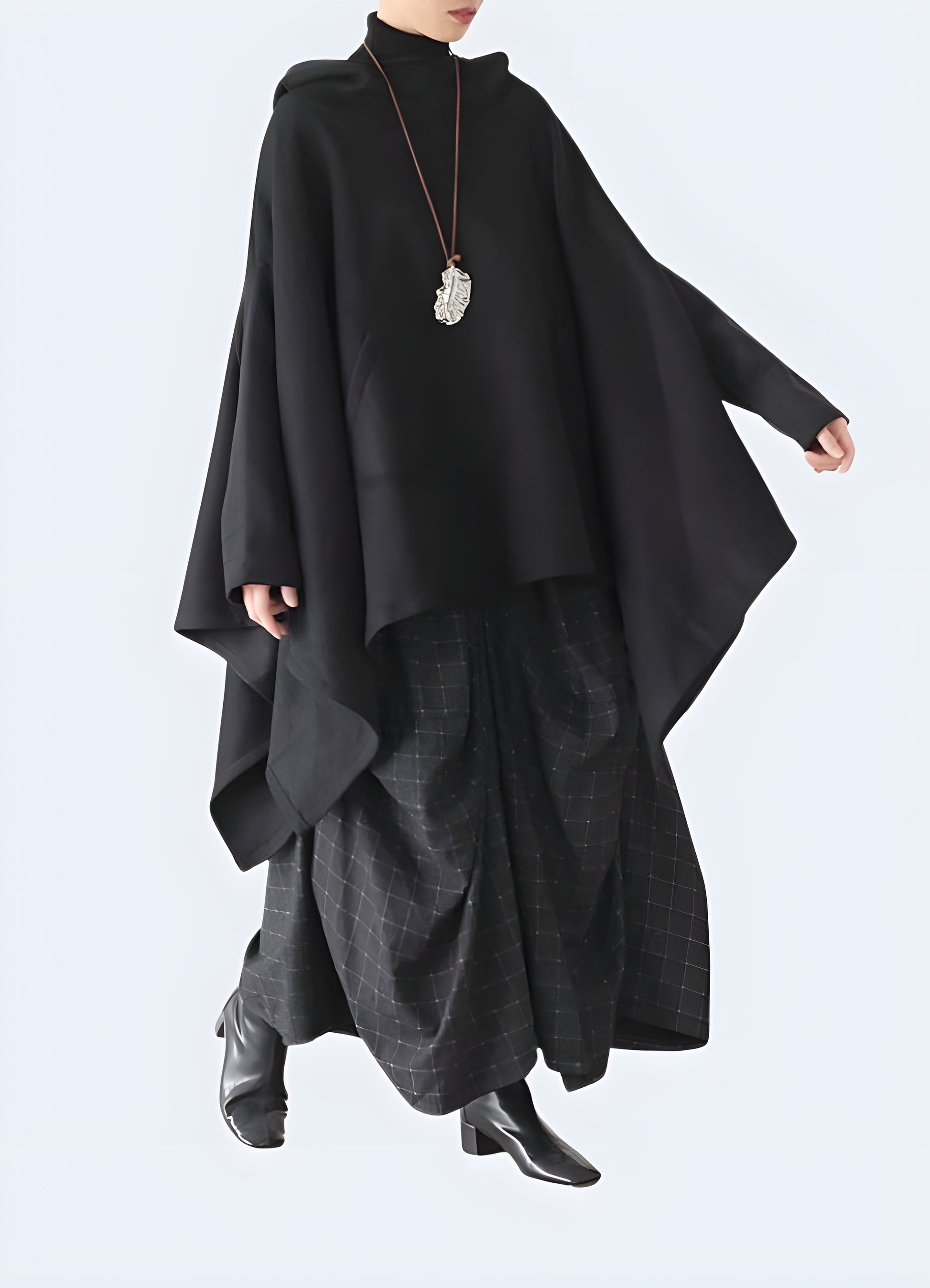 Side view of a model wearing a hooded tactical cloak, emphasizing its high-quality materials and attention to detail for optimal performance and style in the UK.