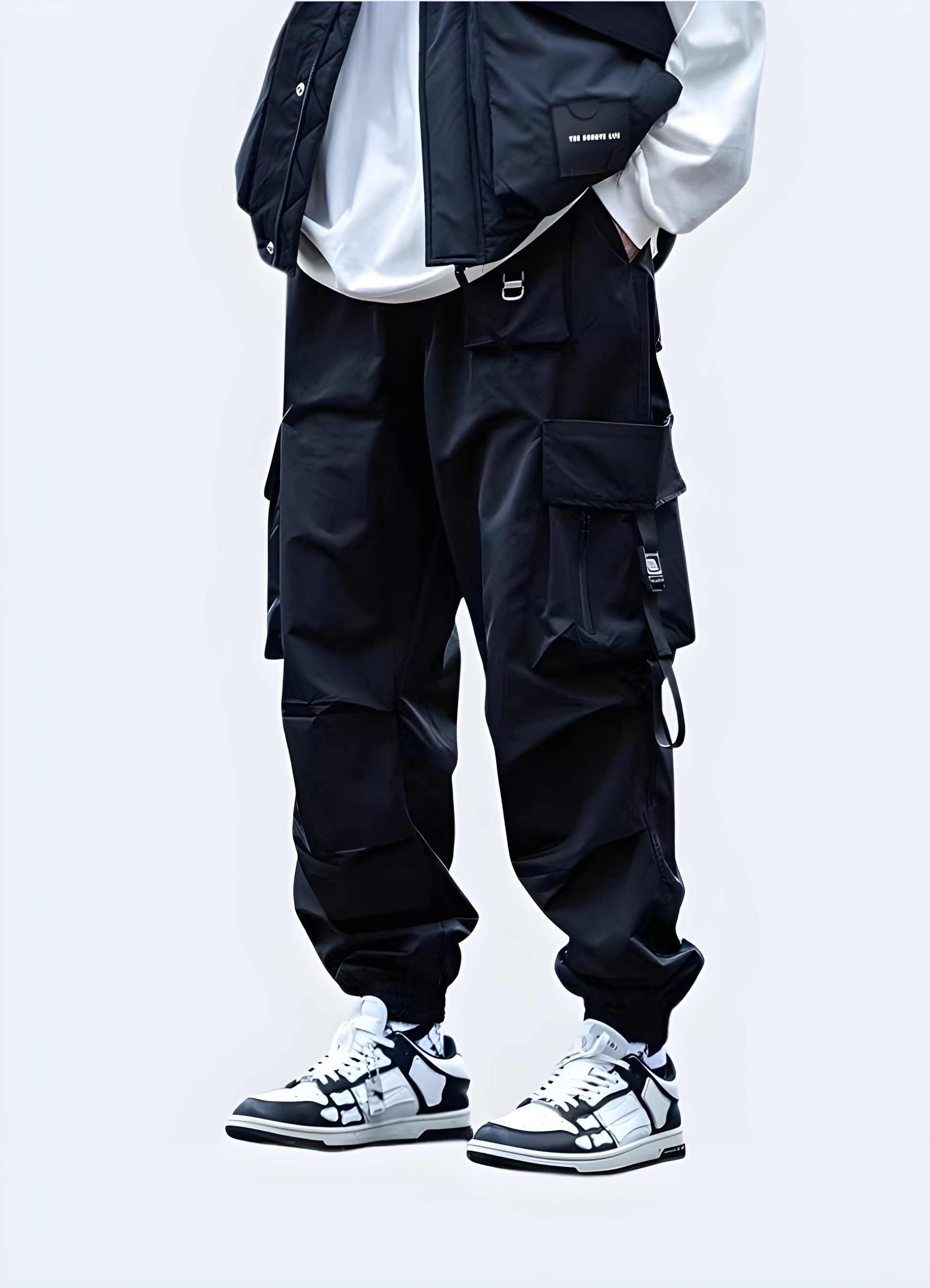 Man wearing black Japanese techwear cargo pants with adjustable straps and tapered fit, back view, UK fashion.