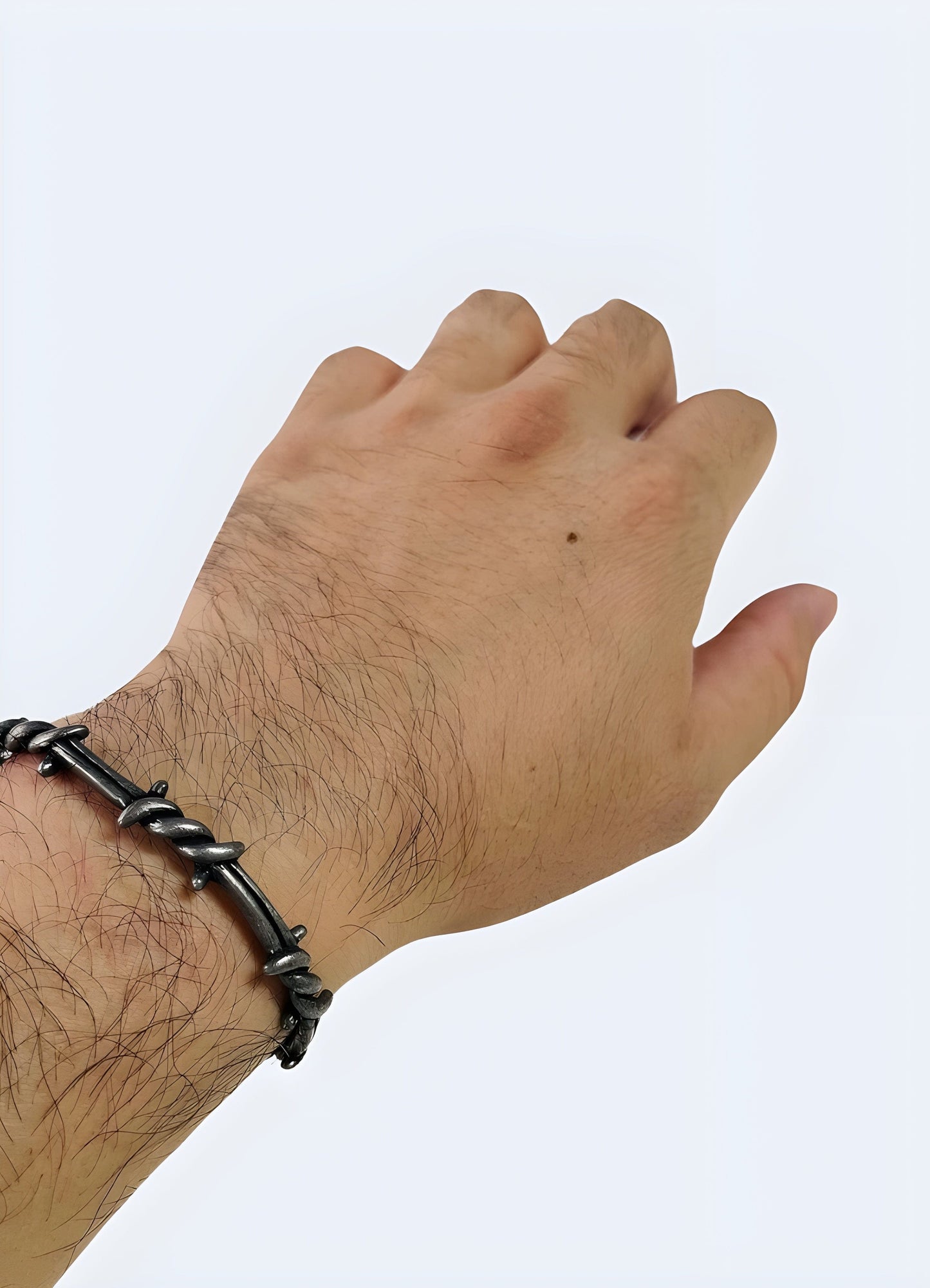 Front view of a man wearing a barbed wire bangle, highlighting its edgy style, available in the UK.