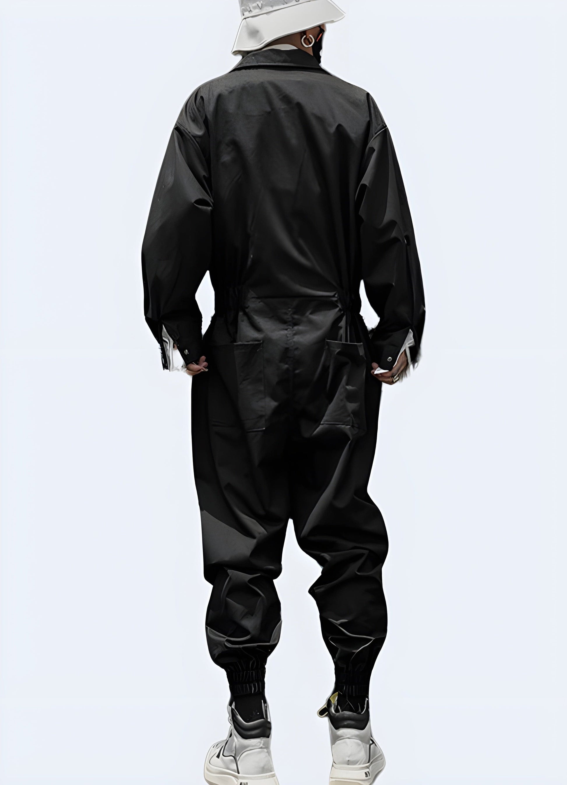 Back view of a man wearing black cargo overalls, showcasing the garment's practical design and numerous pockets, ideal for utility and style in UK settings.