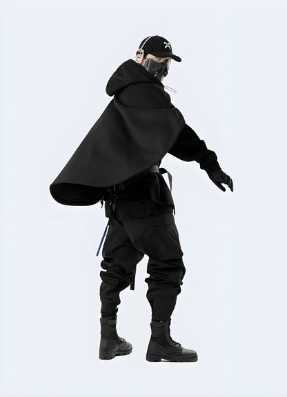 Side view of a man wearing a black sci-fi poncho, showcasing the edgy design and high-tech materials, perfect for making a statement in the UK alternative fashion scene.