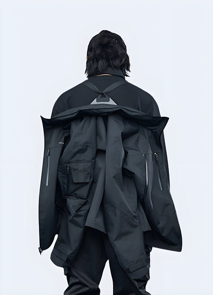 Rear view of a man sporting a black CatsstacTM waterproof jacket, highlighting the stylish and functional design for outdoor enthusiasts.