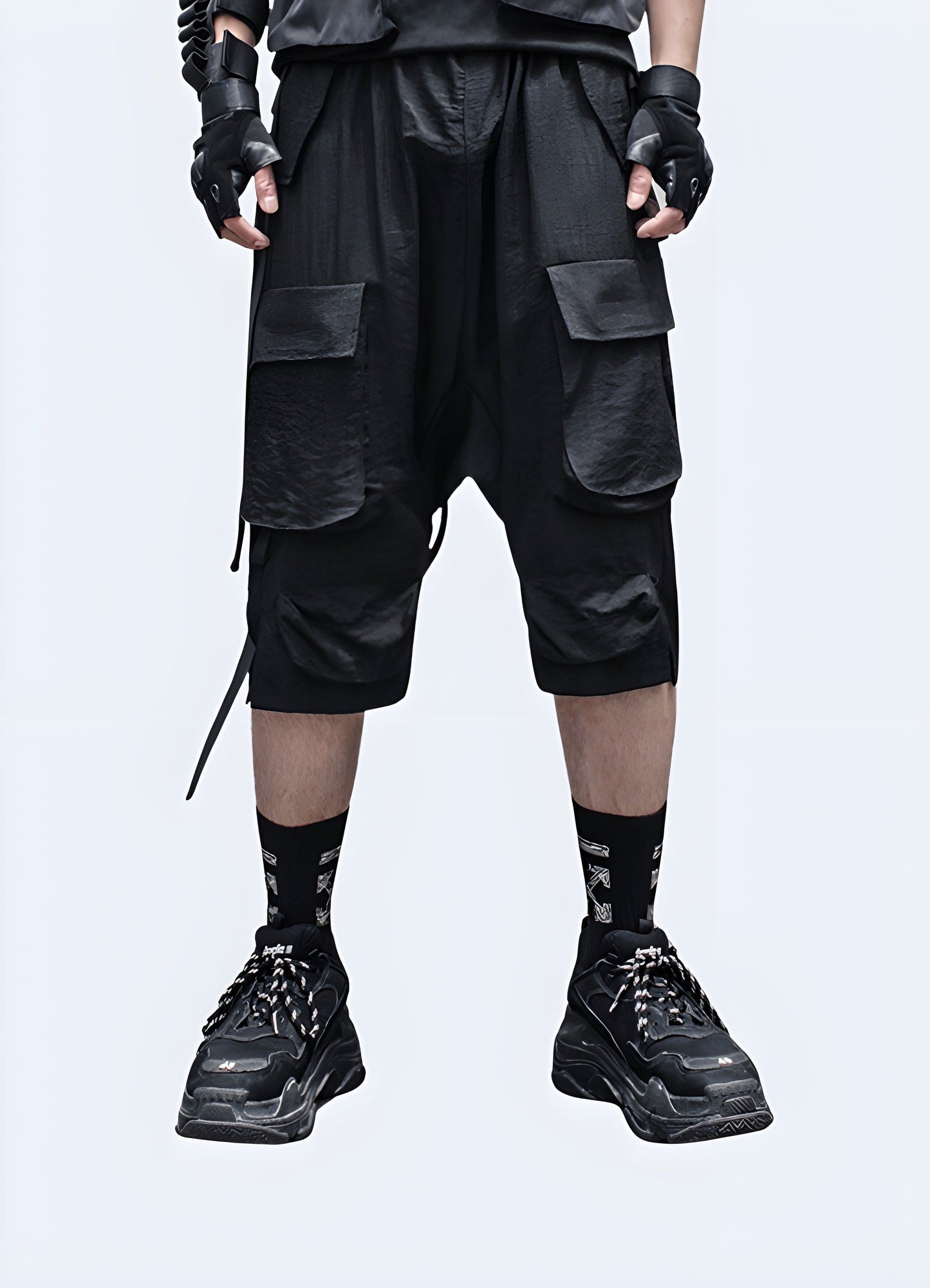 Front view of a man wearing innovative drop crotch techwear shorts, showcasing the garment's modern silhouette, technical features, and streamlined design that redefines contemporary fashion.