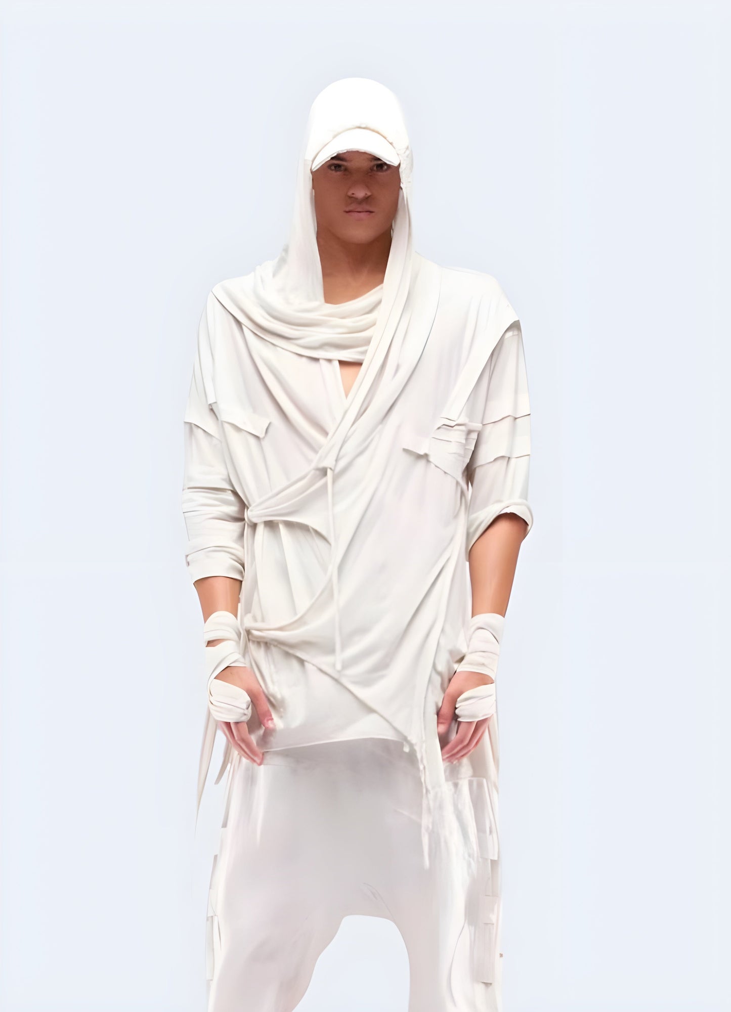 Front view of a man sporting a white dystopian techwear cloak, highlighting its striking contrast and avant-garde design, ideal for those who embrace a futuristic dystopian look in the UK.