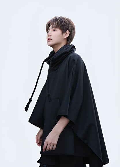 Front view of a man wearing a high collar poncho, showcasing the elegant silhouette and refined aesthetic, ideal for making a fashion statement in the UK.