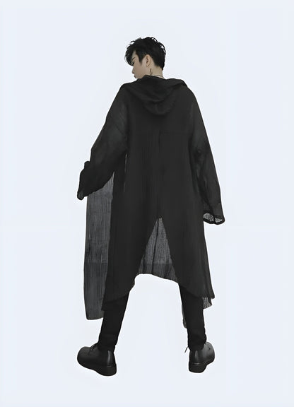 Back view of a man wearing a hooded streetwear cloak, highlighting its oversized silhouette and edgy aesthetics, ideal for elevating any streetwear outfit in the UK.