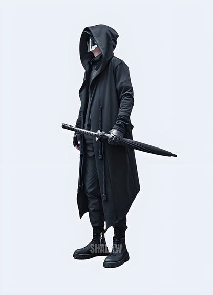 Side view of a man wearing a hooded technical cloak, showcasing its sleek silhouette and advanced features for navigating various environments in the UK.