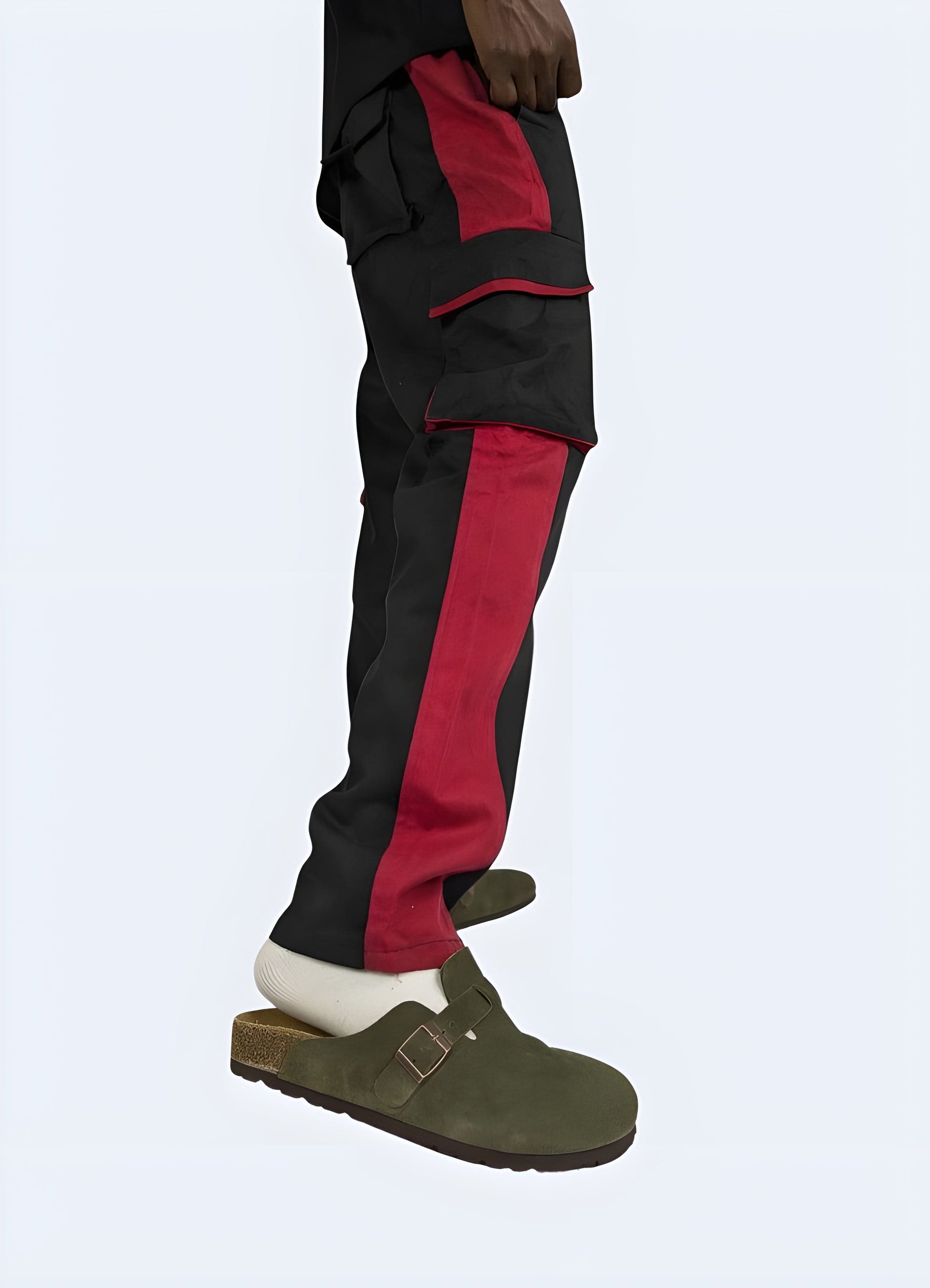 Man wearing red techwear pants, side view, sleek streetwear style, available in UK sizes.