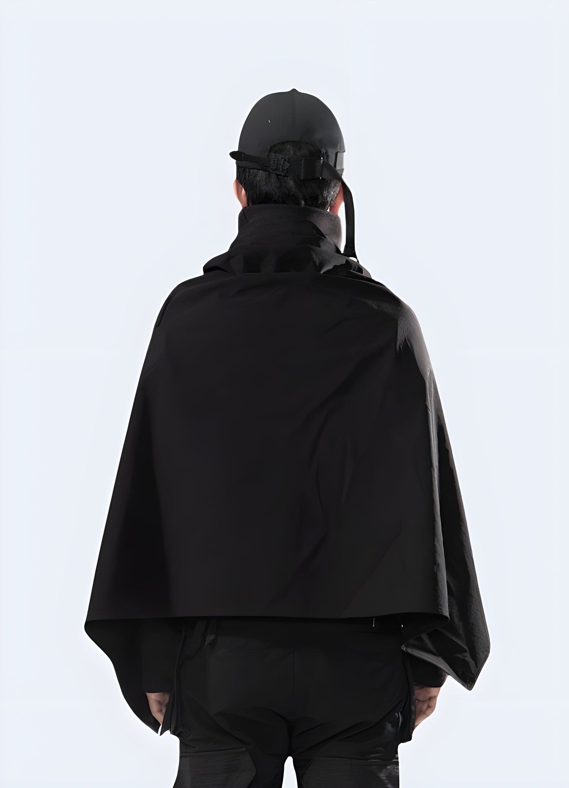 Back view of a man wearing a techwear cloak, showcasing its unique silhouette and advanced materials for a futuristic and functional look in the UK.