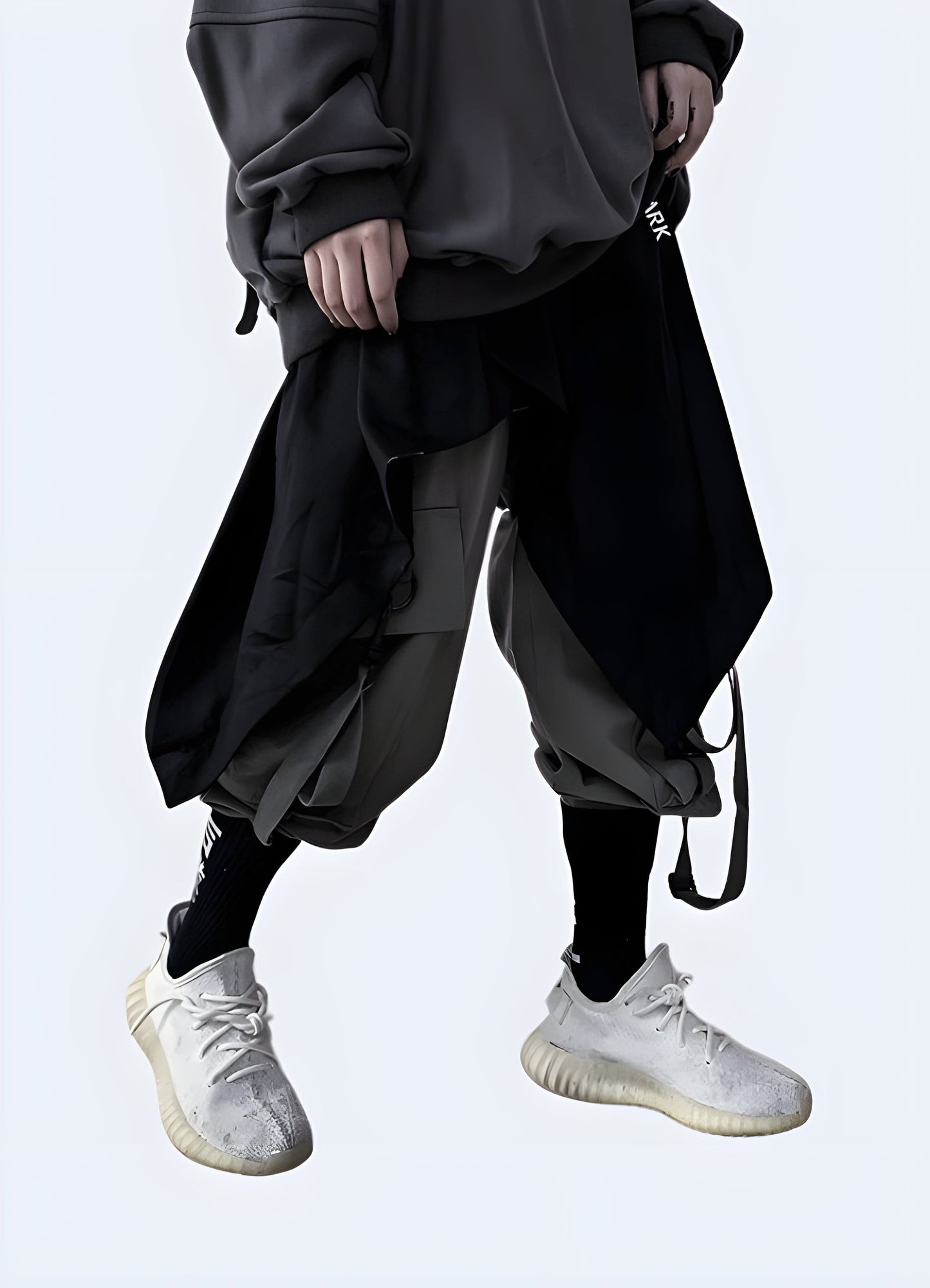  Front side view of a man wearing trendy techwear harem pants, showcasing the garment's unique style and comfortable fit, perfect for the UK streetwear scene.