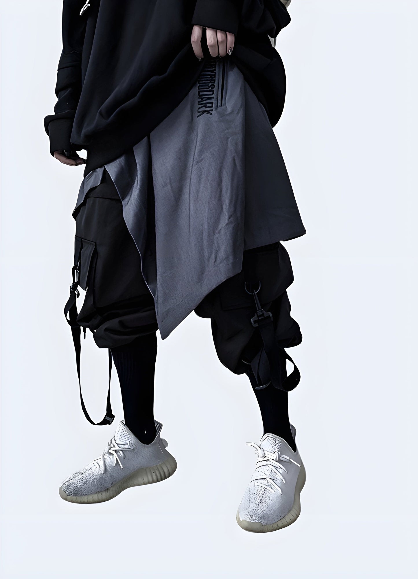  Front side view of a man modeling stylish gray techwear harem pants, highlighting the advanced fabric technology and modern aesthetics, a must-have for fashion-forward techies in the UK.