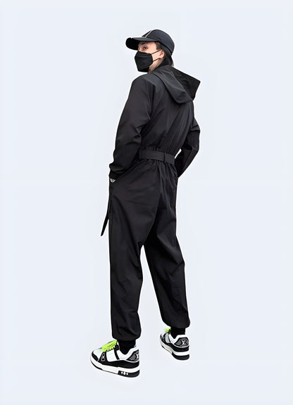 Back view of a man modeling a cutting-edge black techwear jumpsuit with multiple pockets and a hood, perfect for urban exploration and fashion-forward style in the UK.