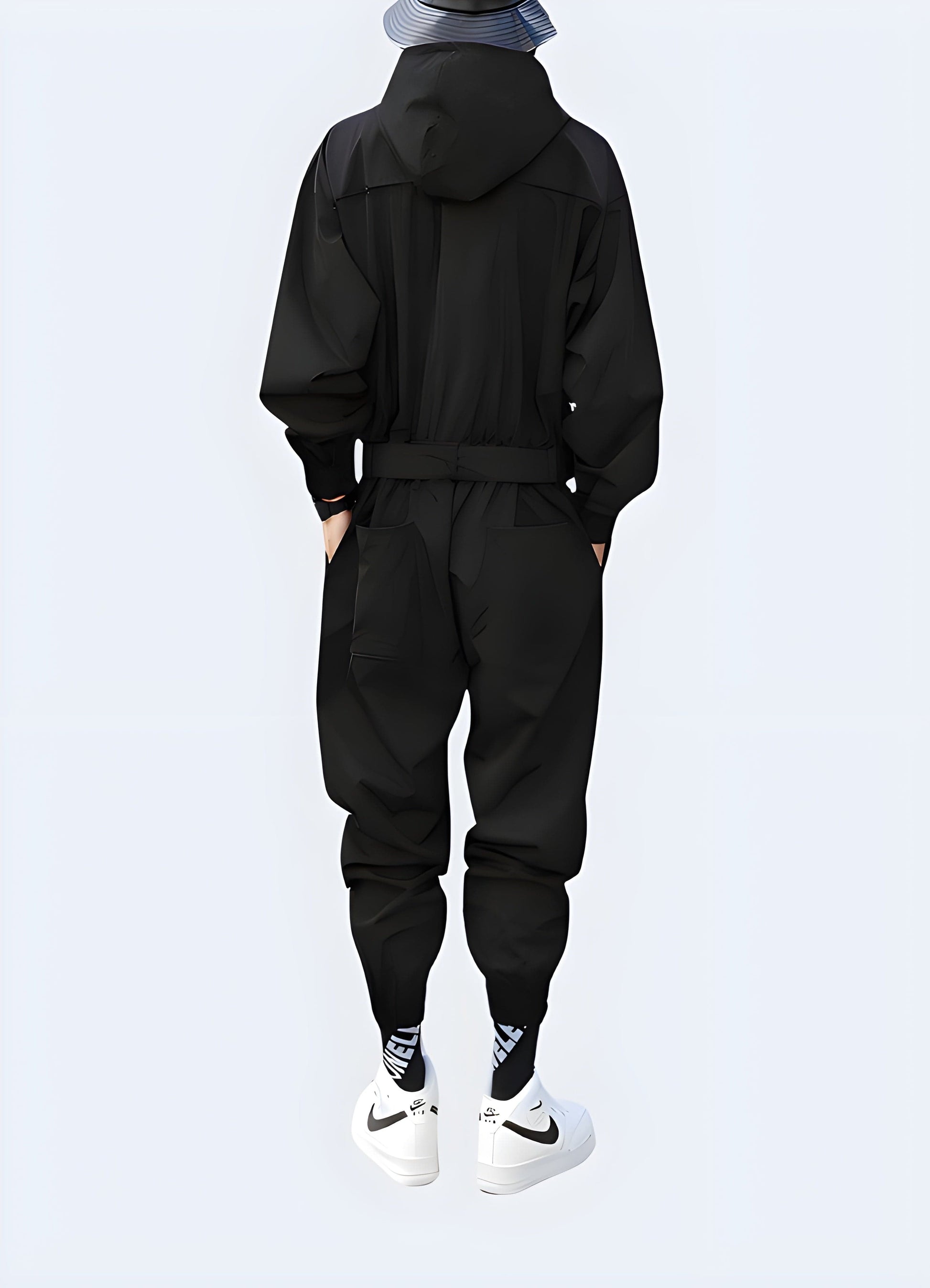 Back view of a man wearing a sleek black techwear jumpsuit with hood, showcasing the garment's unique design and functionality in an urban UK environment.