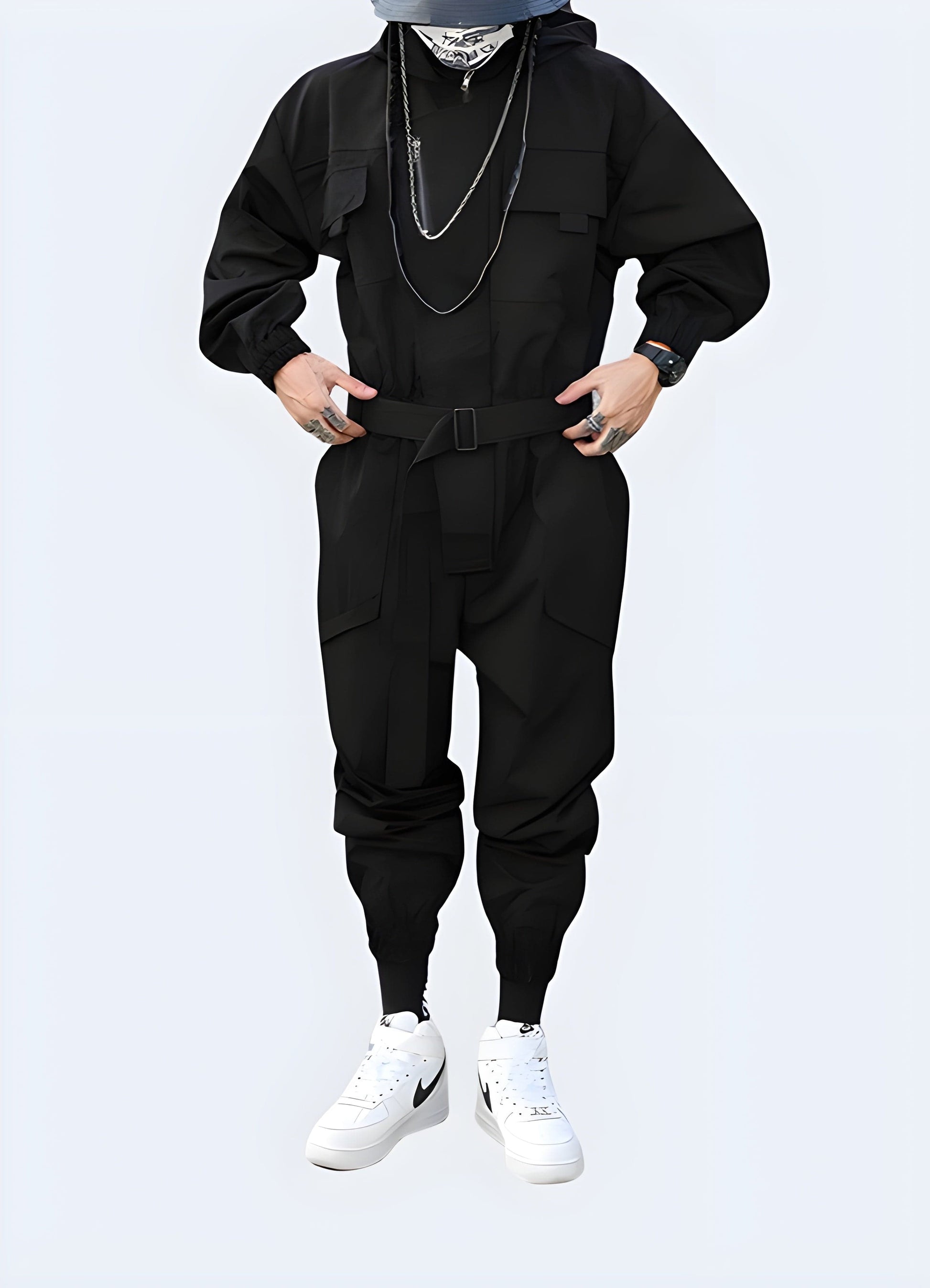 Front view of a man modeling a cutting-edge black techwear jumpsuit with multiple pockets and a hood, perfect for urban exploration and fashion-forward style in the UK.