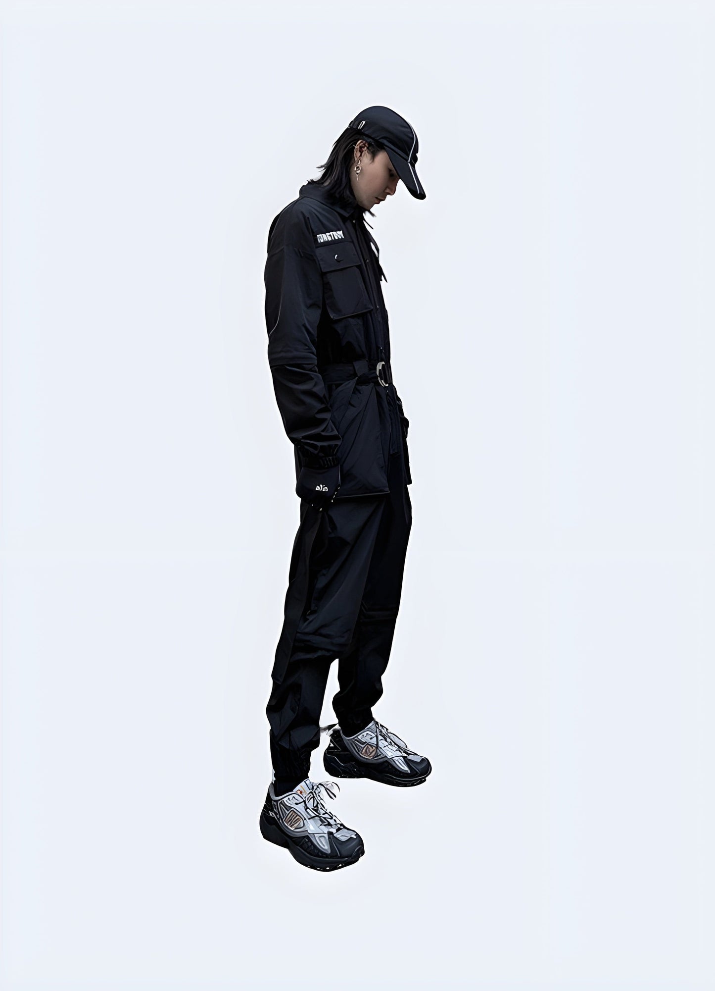 Side view of a man modeling cutting-edge black techwear workwear, highlighting the blend of functionality and style, perfect for modern professionals in urban UK settings.