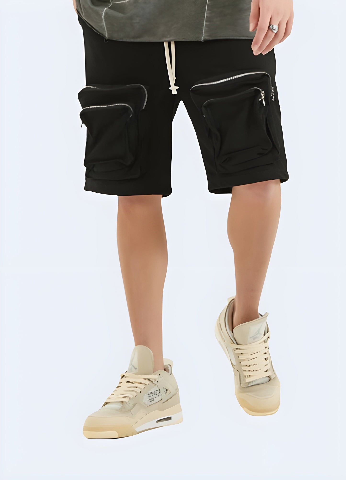 Man wearing black zipper cargo shorts from the front view, highlighting the modern style and practical features, ideal for the UK fashion-conscious utilitarian.