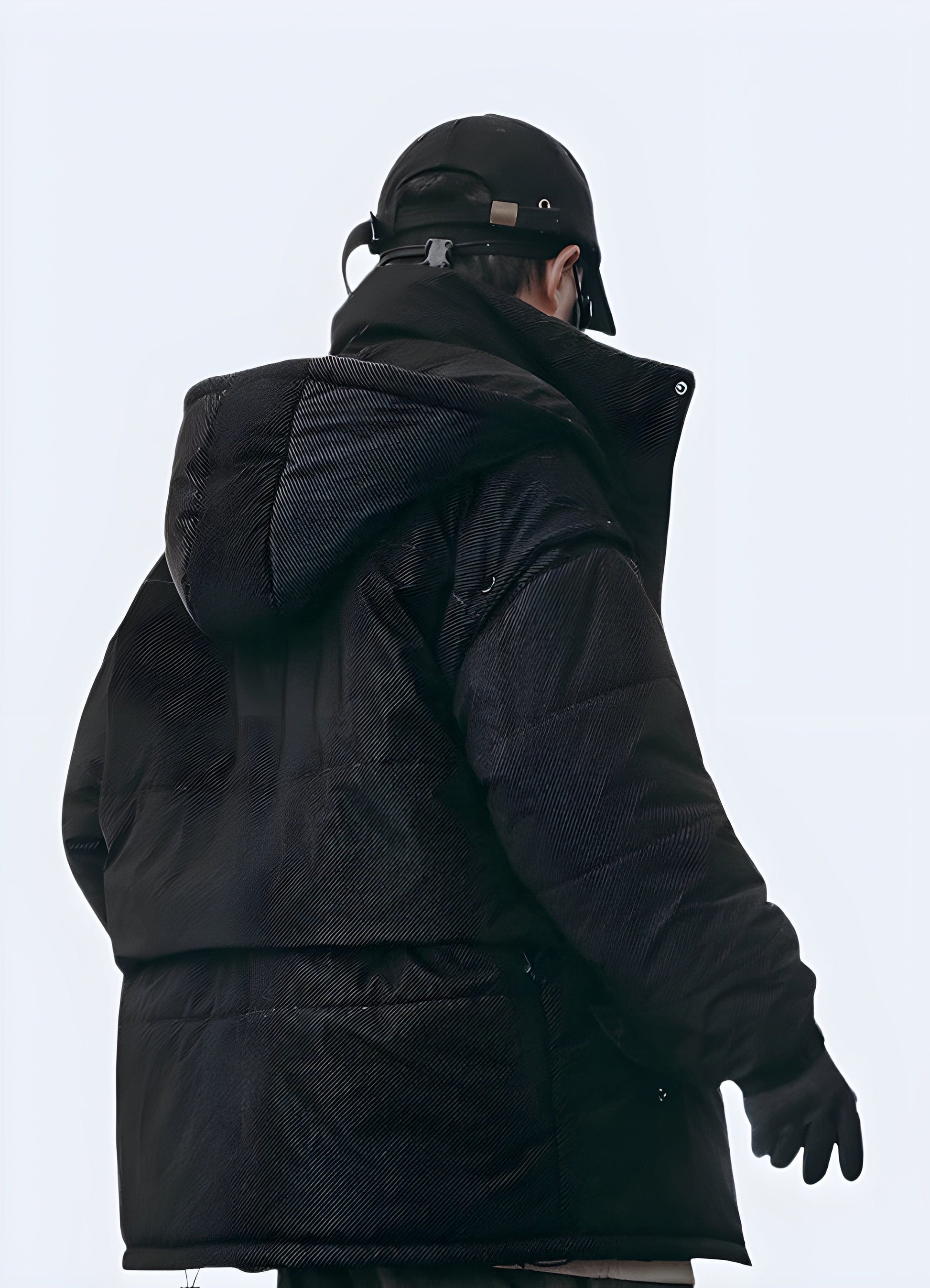 Back side view of a man wearing a technical winter jacket, highlighting its ergonomic fit and durable construction, ideal for withstanding harsh winter weather in the UK.