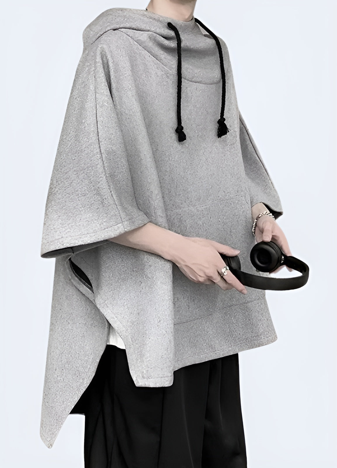 A side view of a light grey techwear poncho featuring multiple pockets, showcasing its sleek design and practical utility.