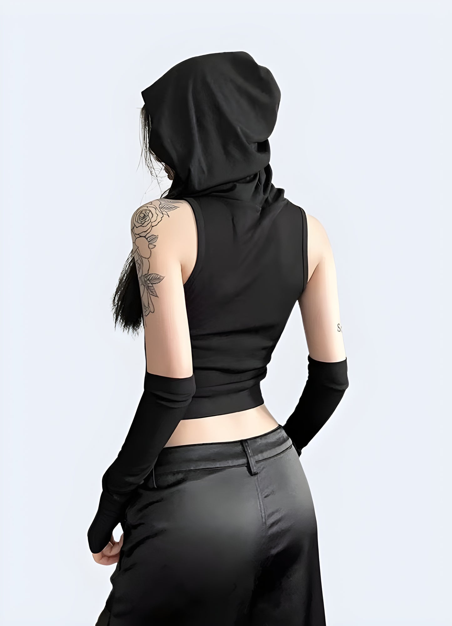 Back view of a woman in a cutting-edge techwear hooded bodysuit, highlighting the garment's unique features and urban style for UK wearers.