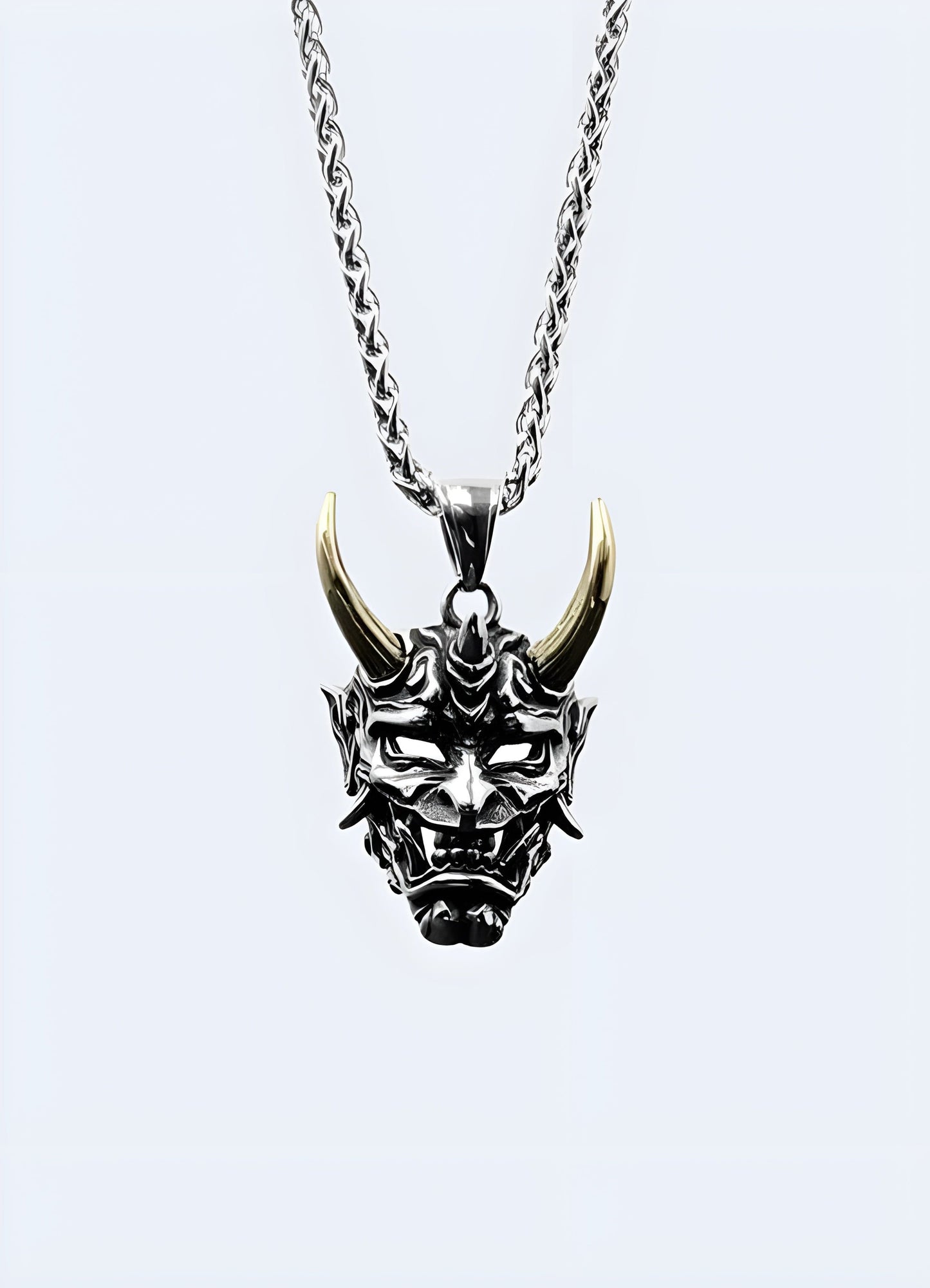 Gold oni mask necklace in a front view, UK, highlighting its detailed craftsmanship.