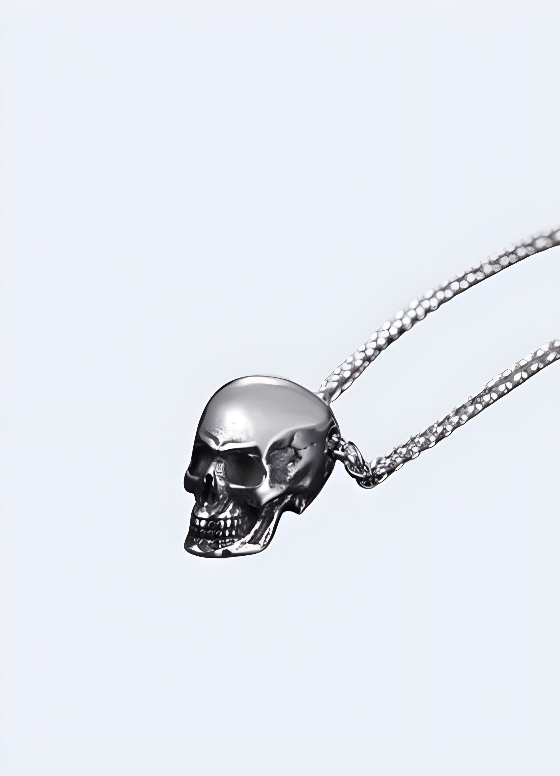 A silver skeleton necklace seen from the side, highlighting its detailed craftsmanship and unique skeletal design, set against a simple background to emphasize its distinct style.