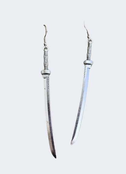 Sword earrings displayed in a front view on a model, UK, showcasing their stylish and unique appearance.