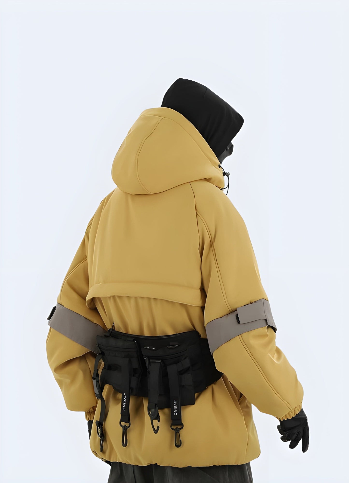 Back view of a model wearing a tactical yellow jacket, showcasing its functional features and eye-catching color, perfect for style-conscious UK consumers prioritizing safety and visibility.