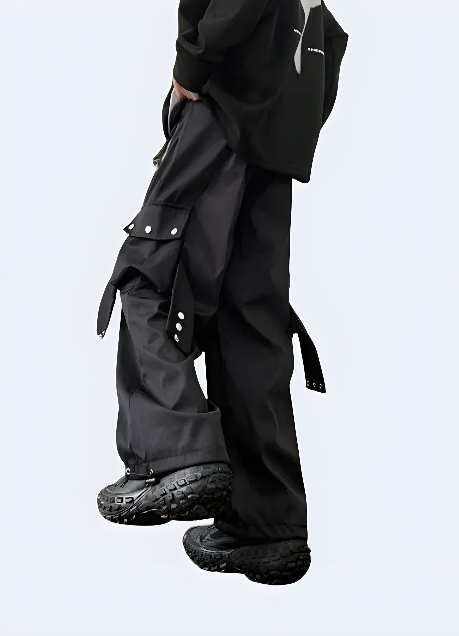 Back view of women wearing black techwear cargo pants – UK streetwear style with functional pockets, tapered fit, and futuristic urban design.