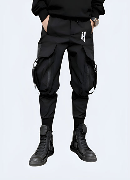 Man wearing black techwear cargo trousers with multiple pockets, front view, UK style.