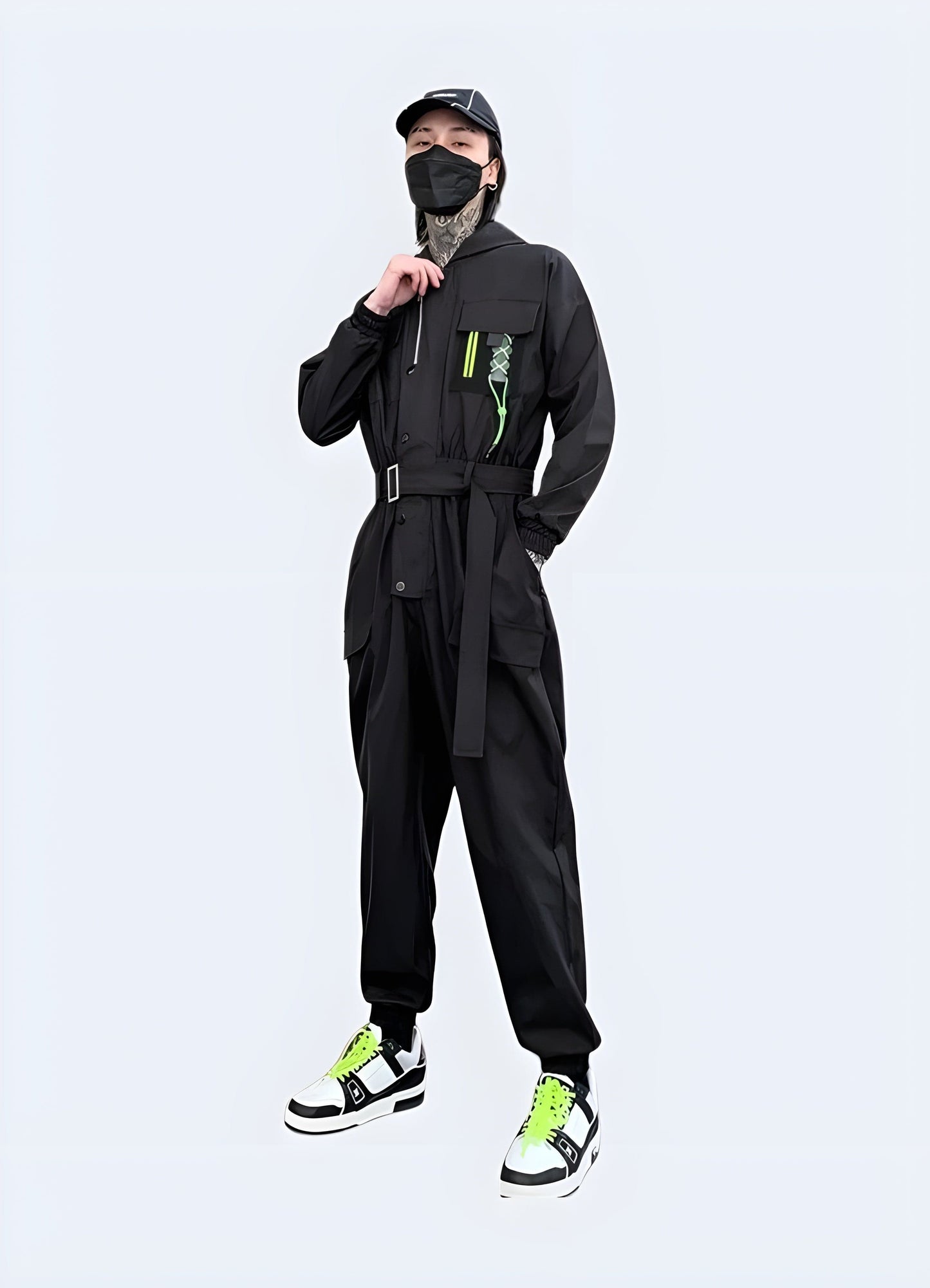 Futuristic black techwear jumpsuit with multiple pockets and straps, worn by a model in an urban setting in the UK.