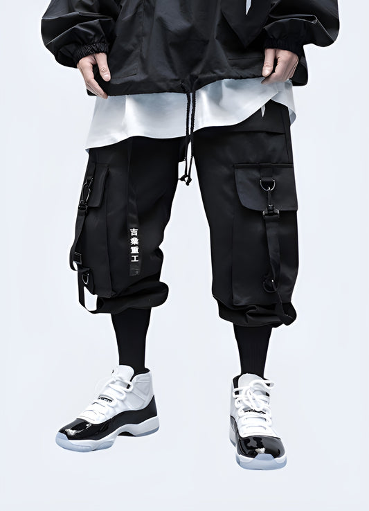 Man wearing black techwear ninja pants, front view, UK streetwear fashion.