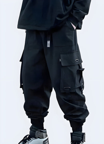 Side view of model in stylish black techwear cargo pants with utility pockets and tapered fit, UK streetwear.