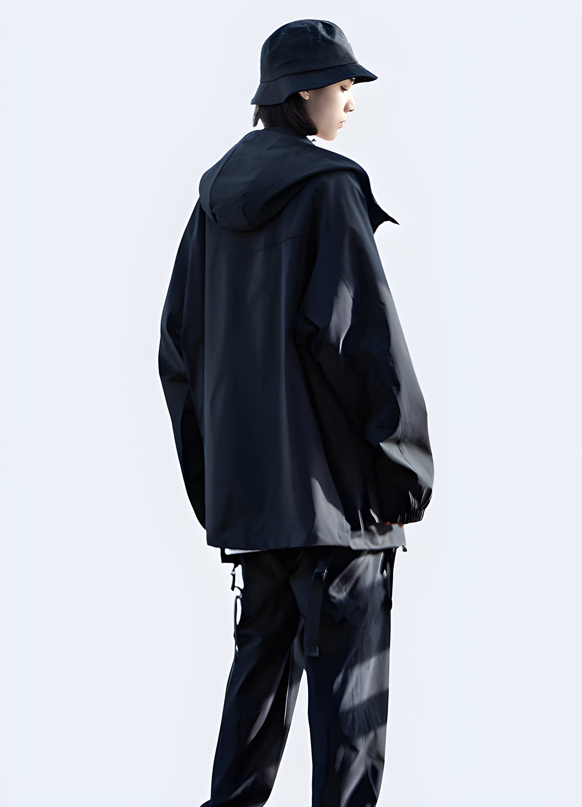 Back view of a model wearing a hooded cargo jacket, showcasing its streamlined silhouette, functional hood, and multiple storage options, ideal for fashion-forward individuals in the UK looking for a stylish and practical jacket.