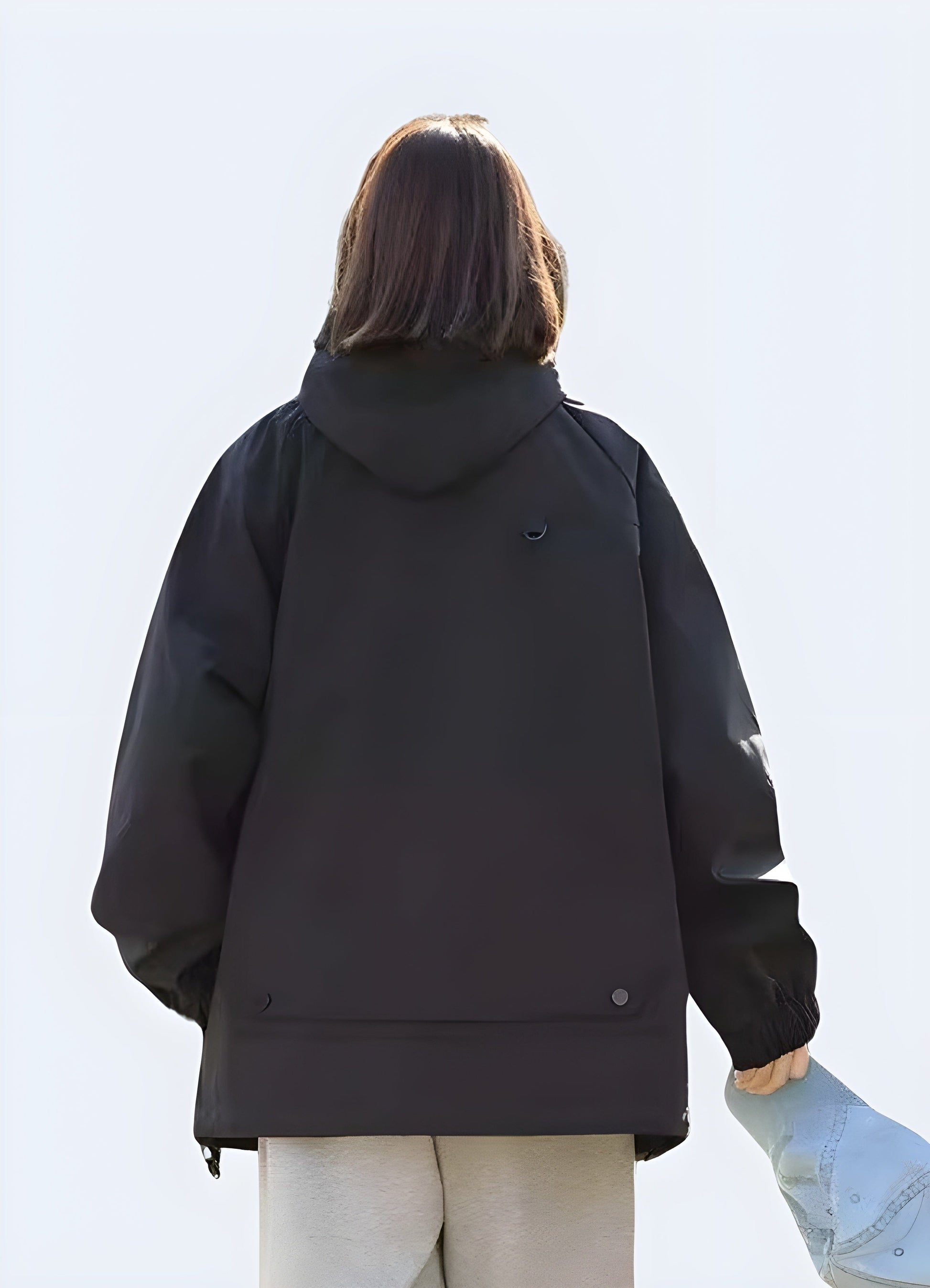 Back view of a model wearing a black hooded cargo jacket, showcasing its sleek design, multiple pockets, and protective hood, perfect for UK consumers seeking a fashionable and functional outerwear option.