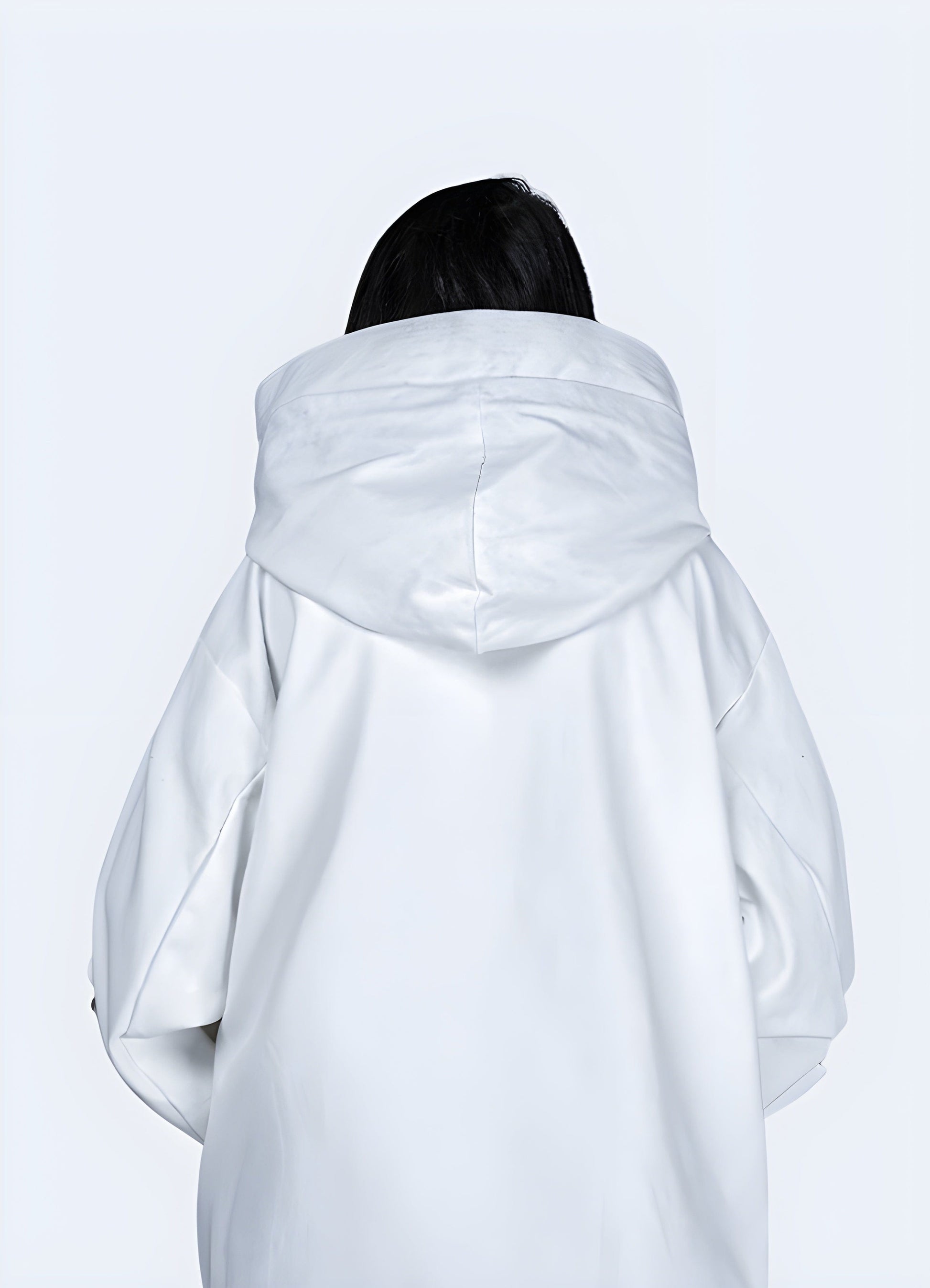 Back view of a woman wearing a white women's techwear jacket, showcasing its clean design and practical features for city life in the UK.