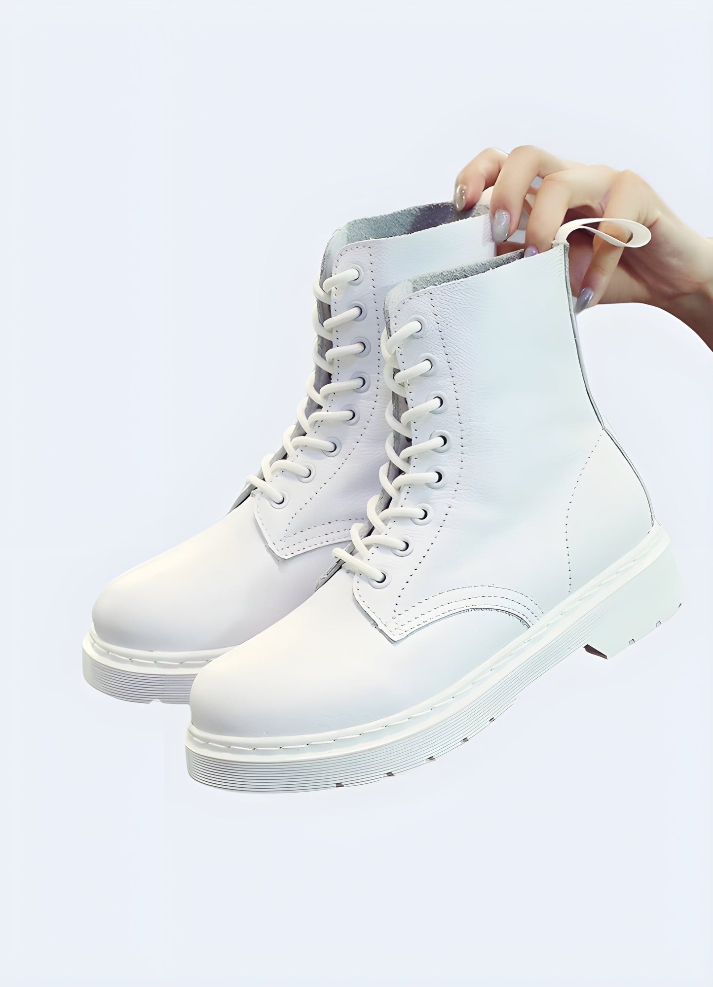 Front and side view of white combat boots, highlighting the sleek silhouette, lace-up closure, and versatile white color suitable for various styles and occasions.