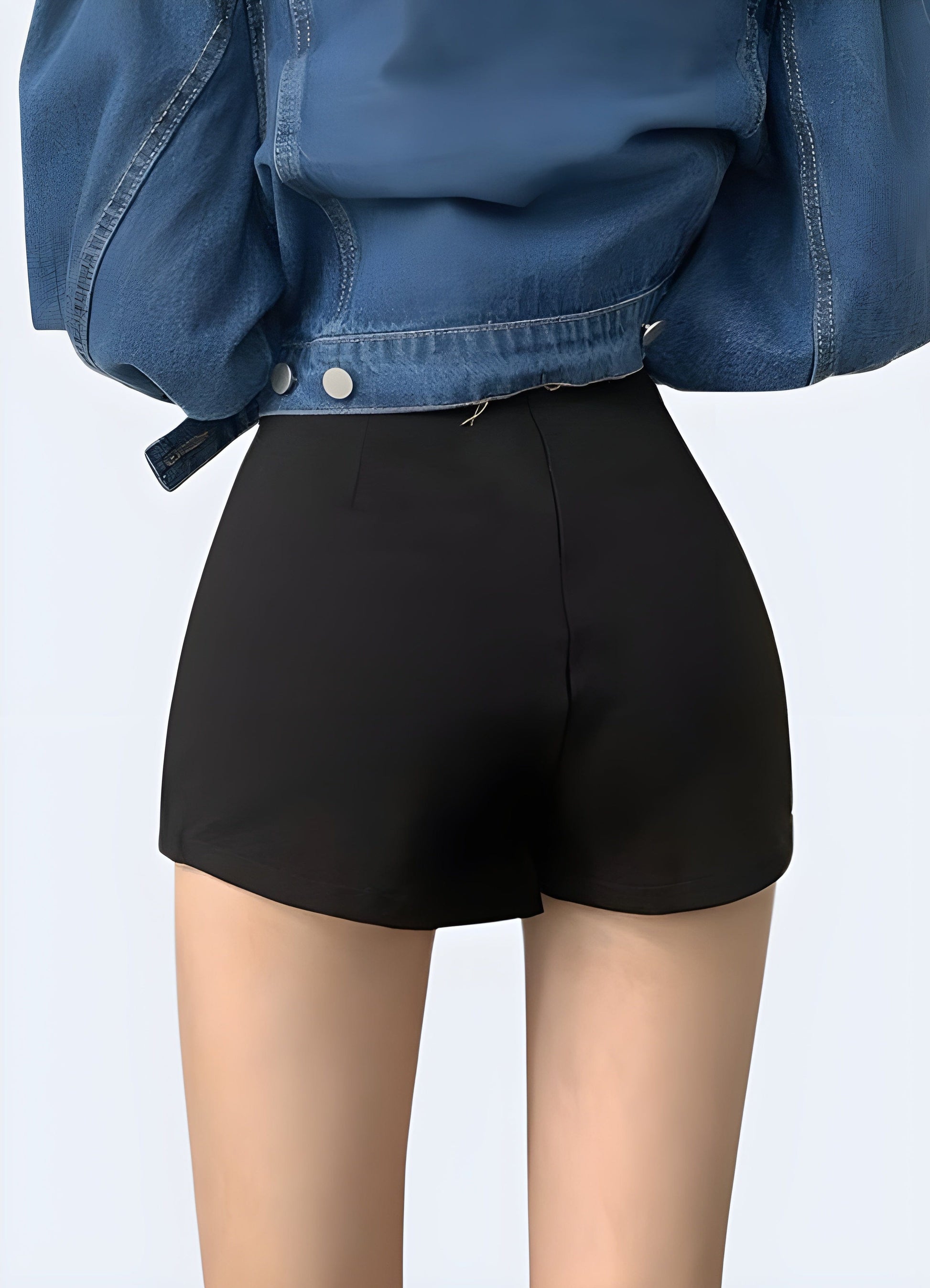 Back view of a woman wearing a black mini skirt, showcasing its flattering fit and ability to elevate any outfit in the UK fashion scene.