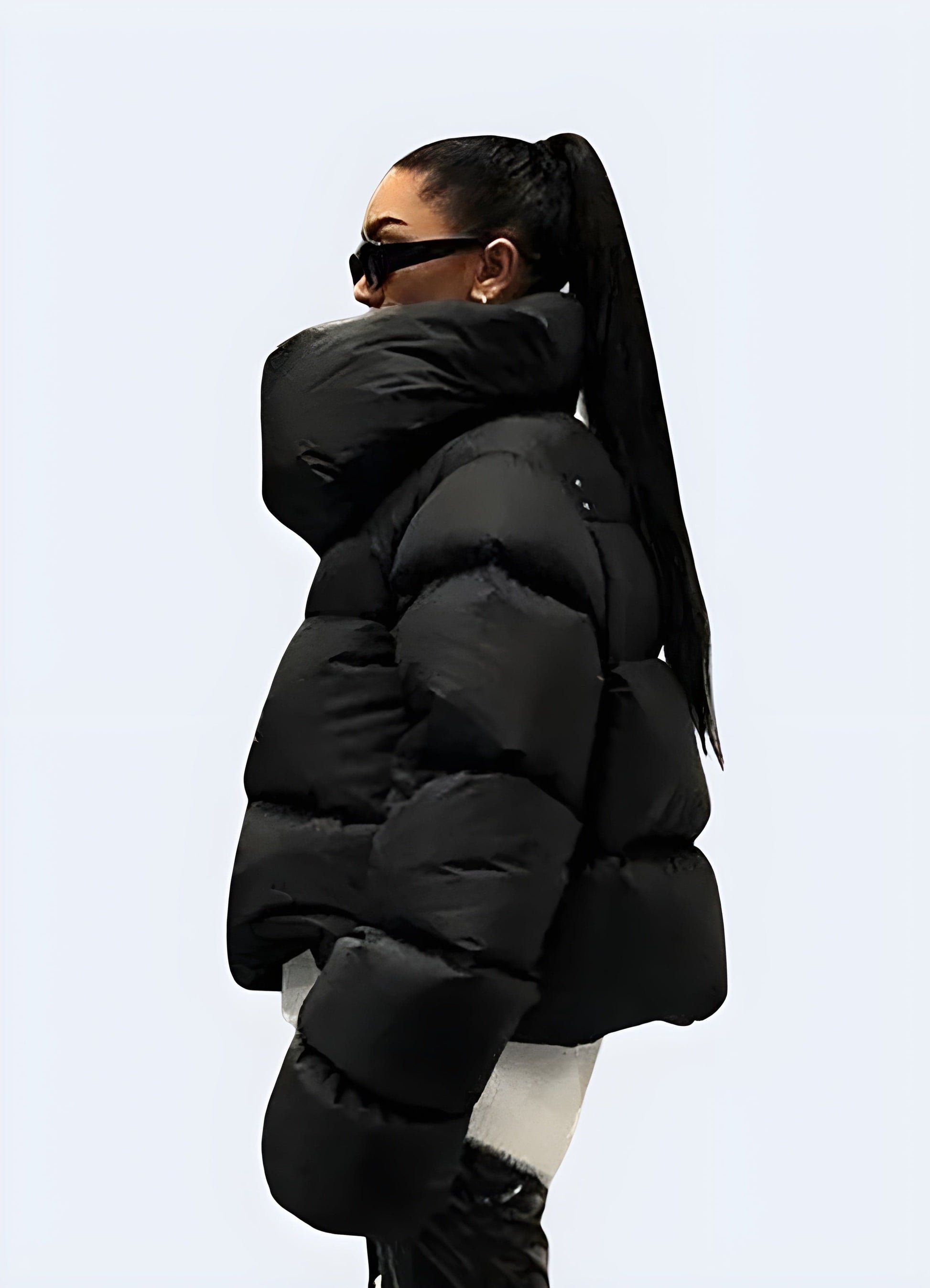 Side view of a woman wearing a techwear down puffer jacket, showcasing its sleek silhouette and functional features for cold weather in the UK.