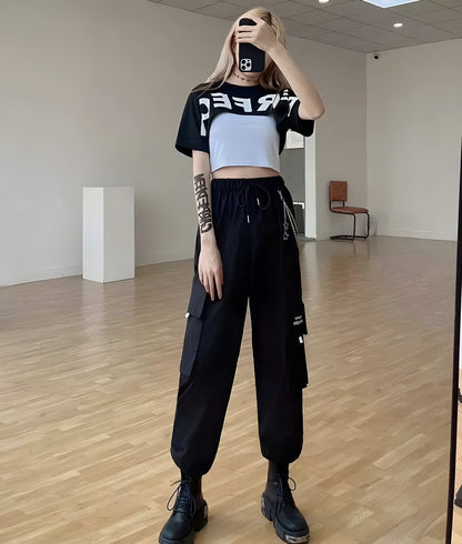 Model view of a woman wearing stylish techwear women's pants with a chain accent, showcasing the blend of fashion and utility popular in UK street style.