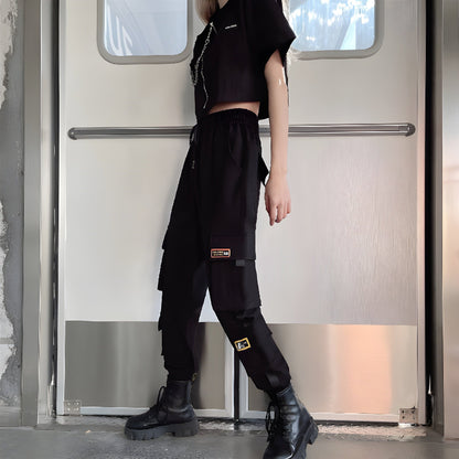 Side view of a woman wearing form-fitting womens techwear pants with adjustable hem,, highlighting the comfort and versatility of this popular style in the UK.