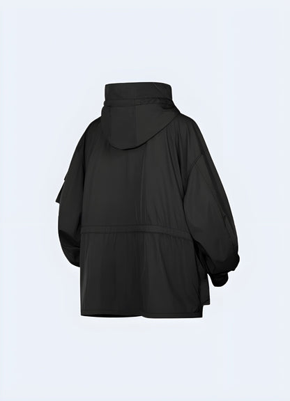 Back view of a women's techwear parka, emphasizing its high-quality construction and practical details for navigating the UK urban landscape in style.