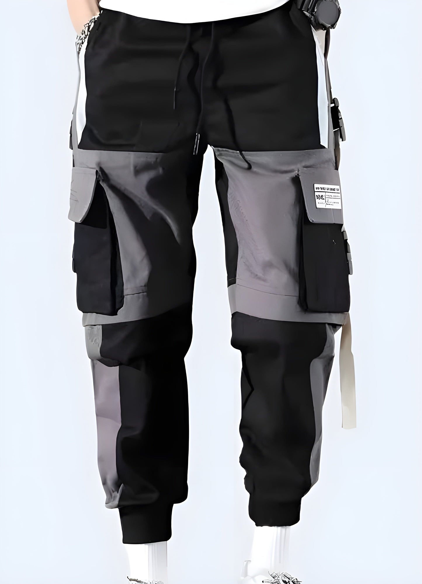 Front view of a man sporting black techwear pants, emphasizing the garment's modern aesthetics and technical features, a must-have for UK individuals embracing the techwear fashion trend.