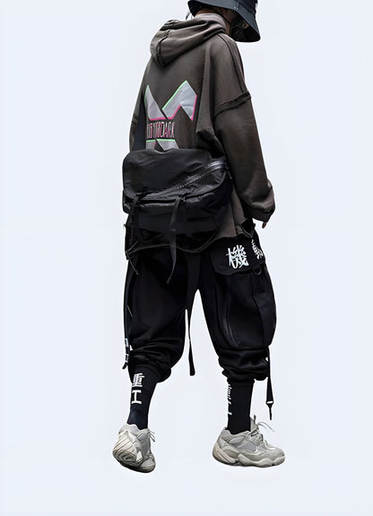  Back view of a man wearing innovative techwear samurai pants, showcasing the garment's distinctive design and advanced materials, perfect for fashion-forward tech enthusiasts in the UK.