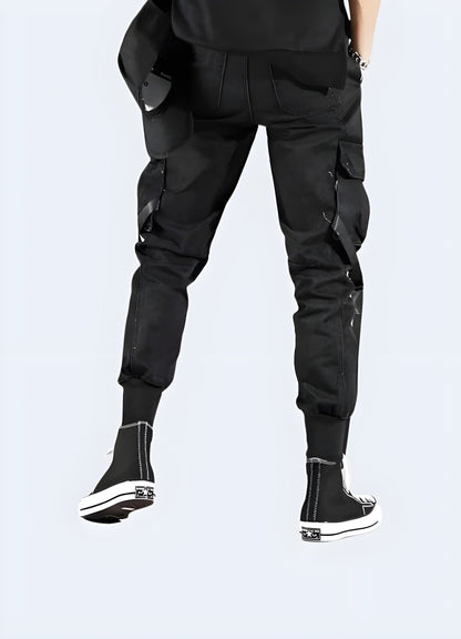 Back view of a man wearing fashionable urban ninja pants, showcasing the garment's sleek silhouette and distinctive details, perfect for fashion-forward individuals in the UK.