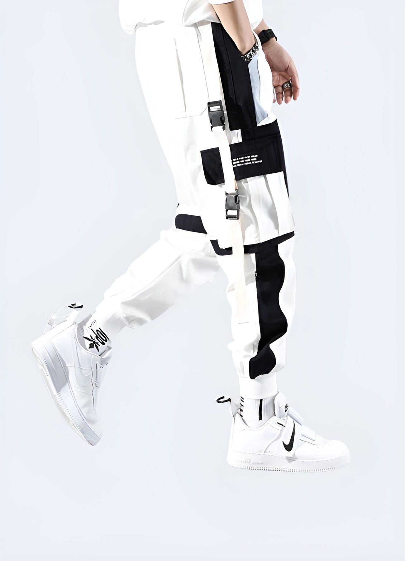 Side view of a man wearing stylish white techwear pants, showcasing the garment's clean lines and advanced fabric technology, perfect for fashion-forward tech enthusiasts in the UK.